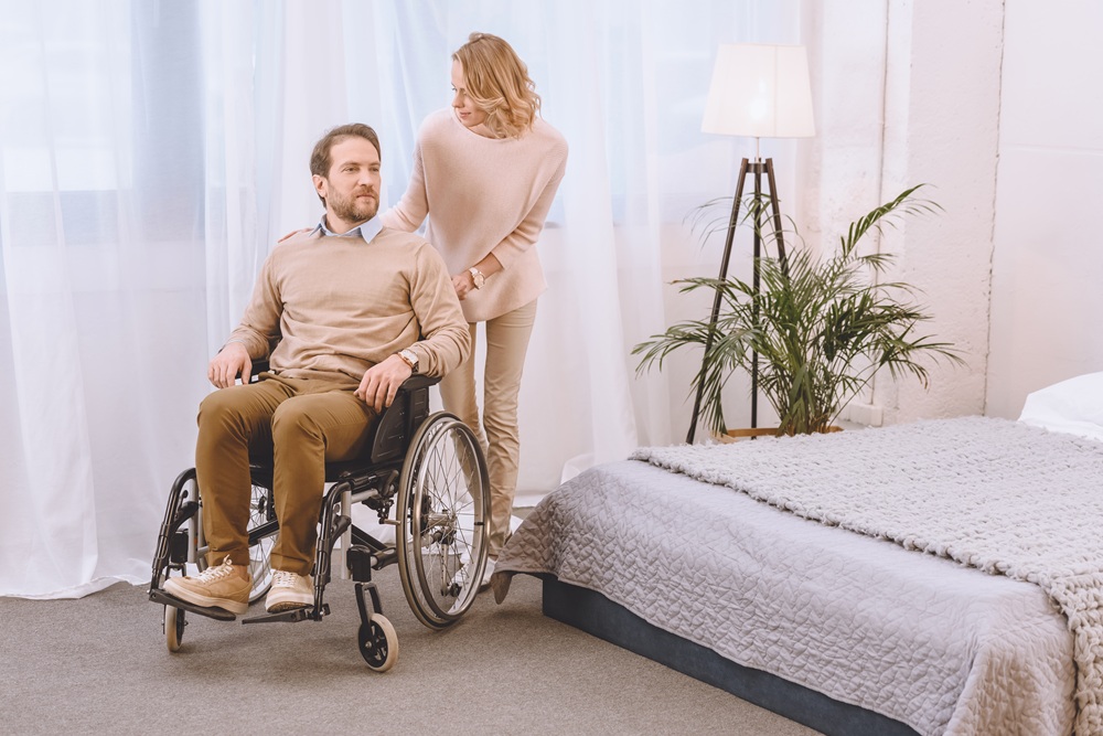 husband on wheelchair and wife in light bedroom